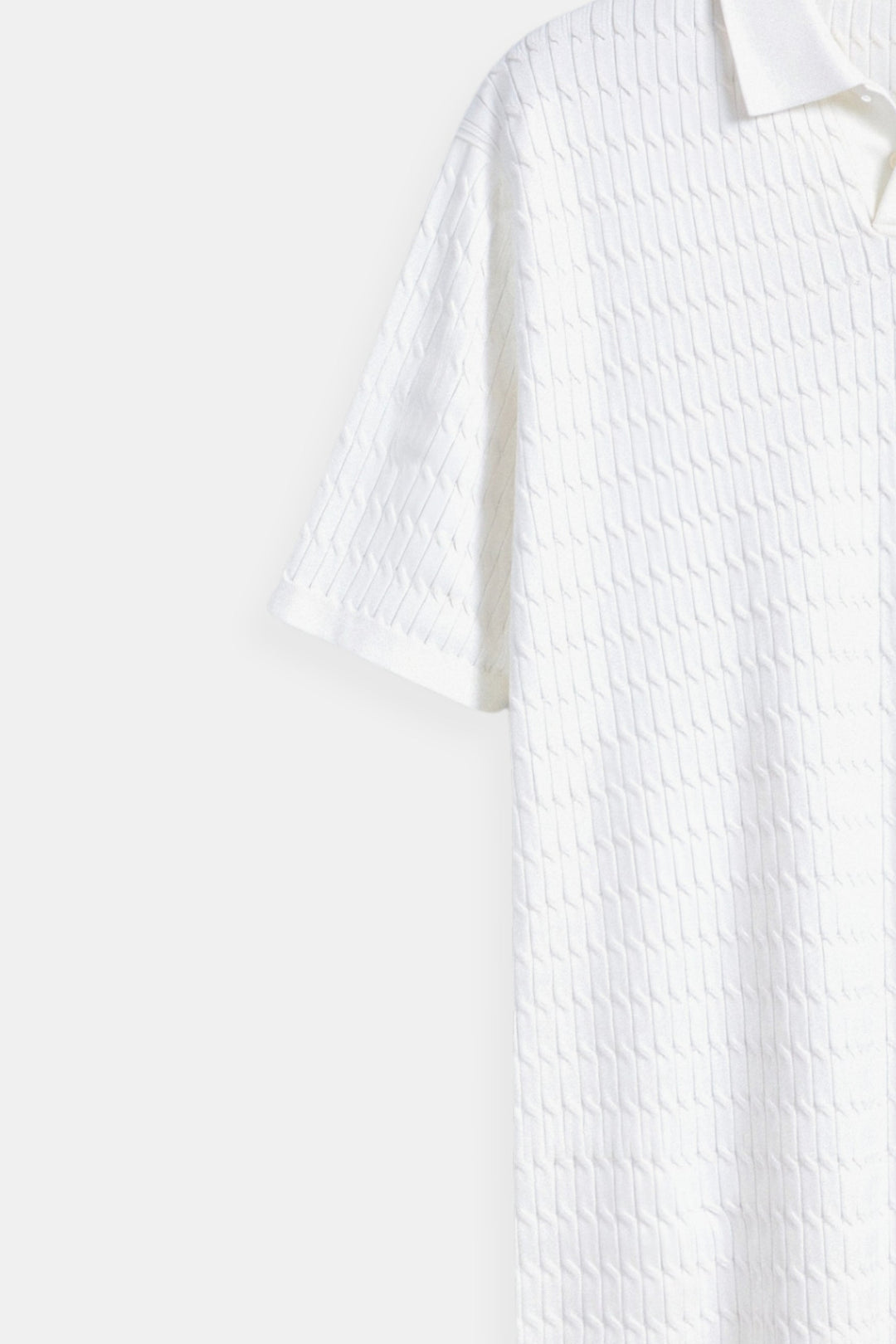 Polo en maille blanche élégante avec un motif de structure raffiné.