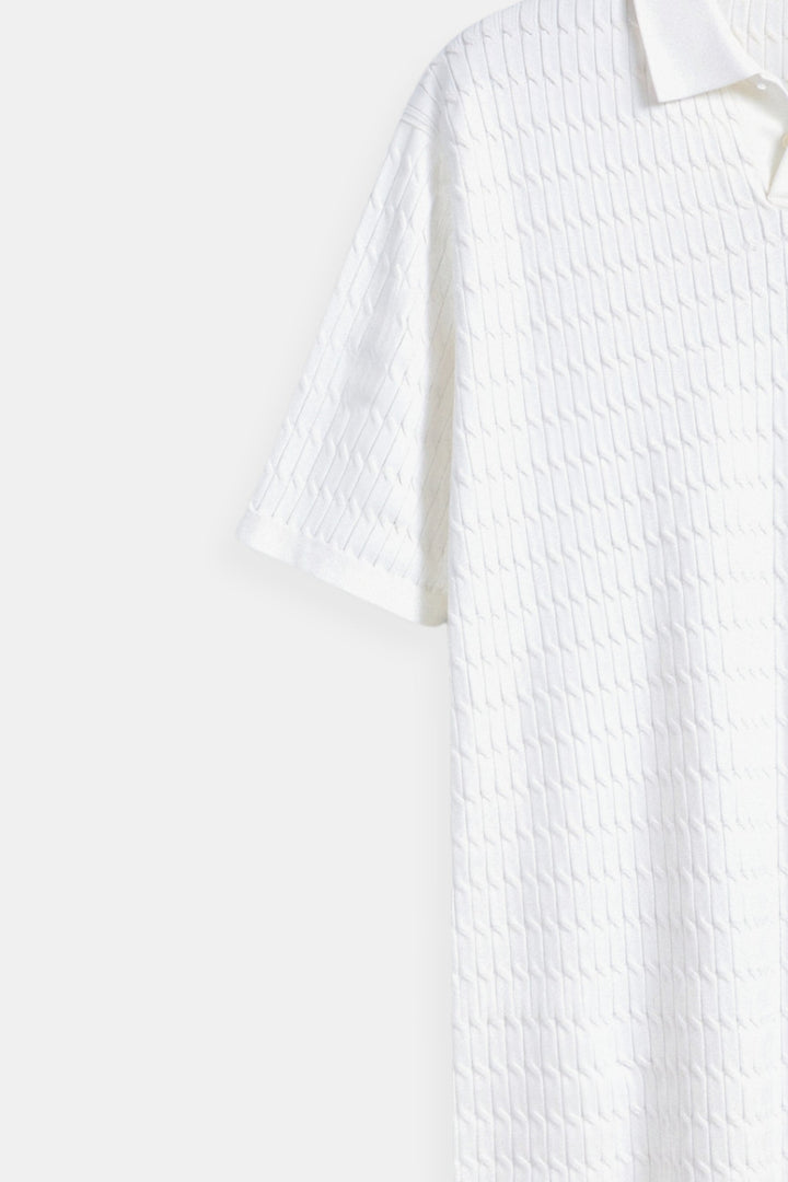 Polo en maille blanche élégante avec un motif de structure raffiné.