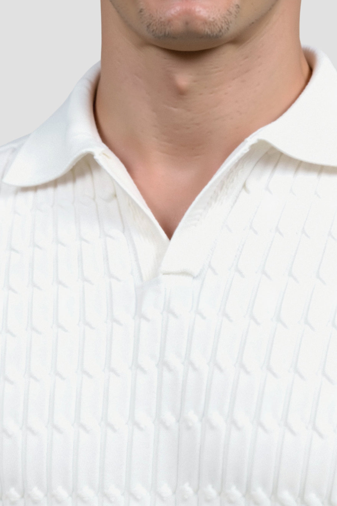 Polo en maille blanche élégante avec un motif de structure raffiné.