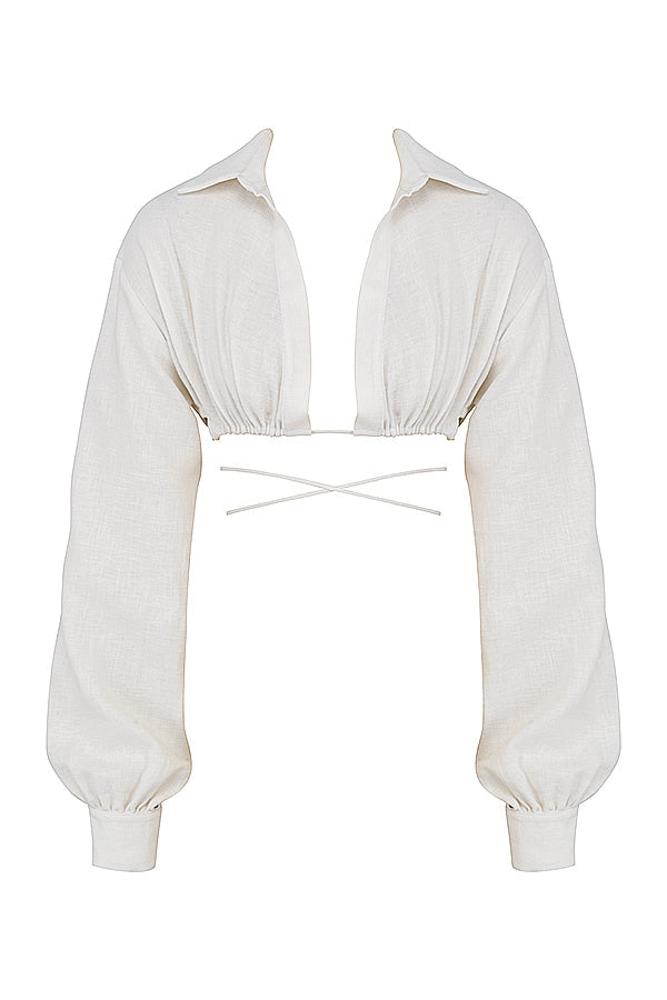 Blouse cropped blanche cassée élégante associée à une mini-jupe taille haute tendance.