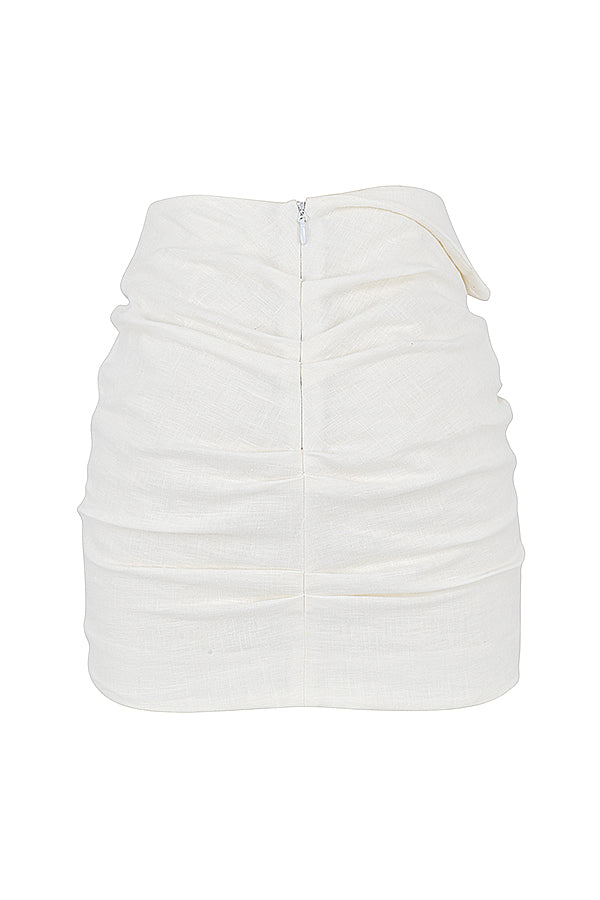 Blouse cropped blanche cassée élégante associée à une mini-jupe taille haute tendance.