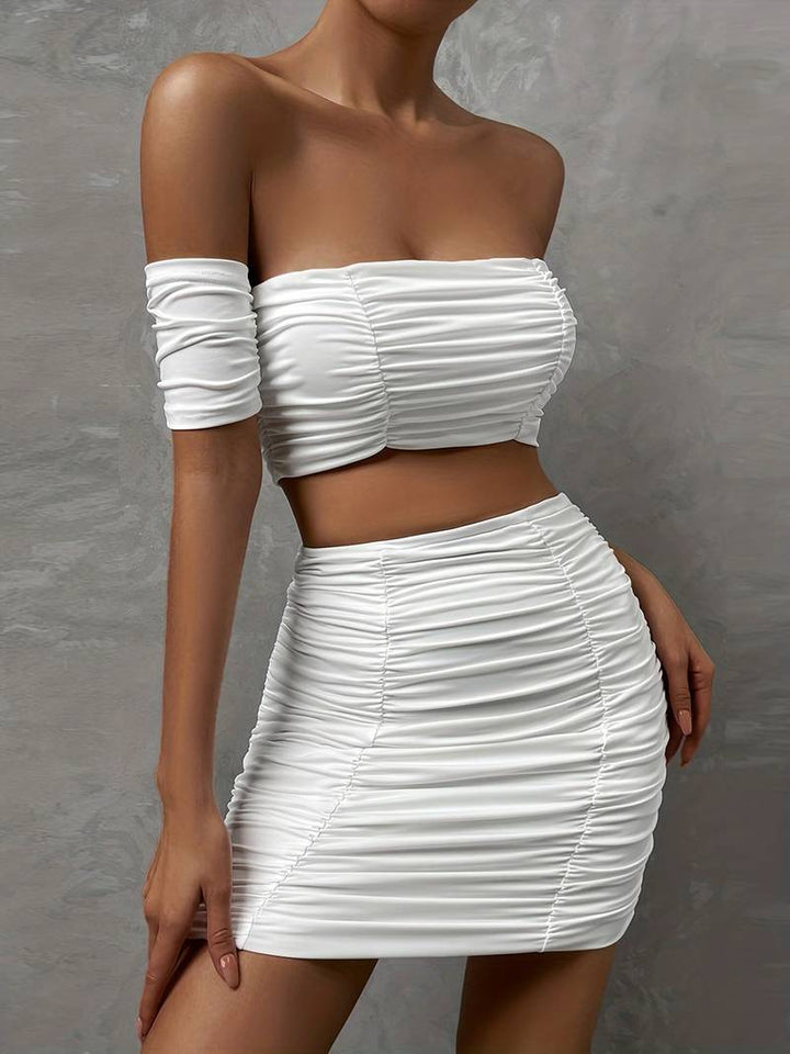 Ensemble chic avec un top à épaules dénudées et des ruchés, accompagné d'une mini-jupe assortie.