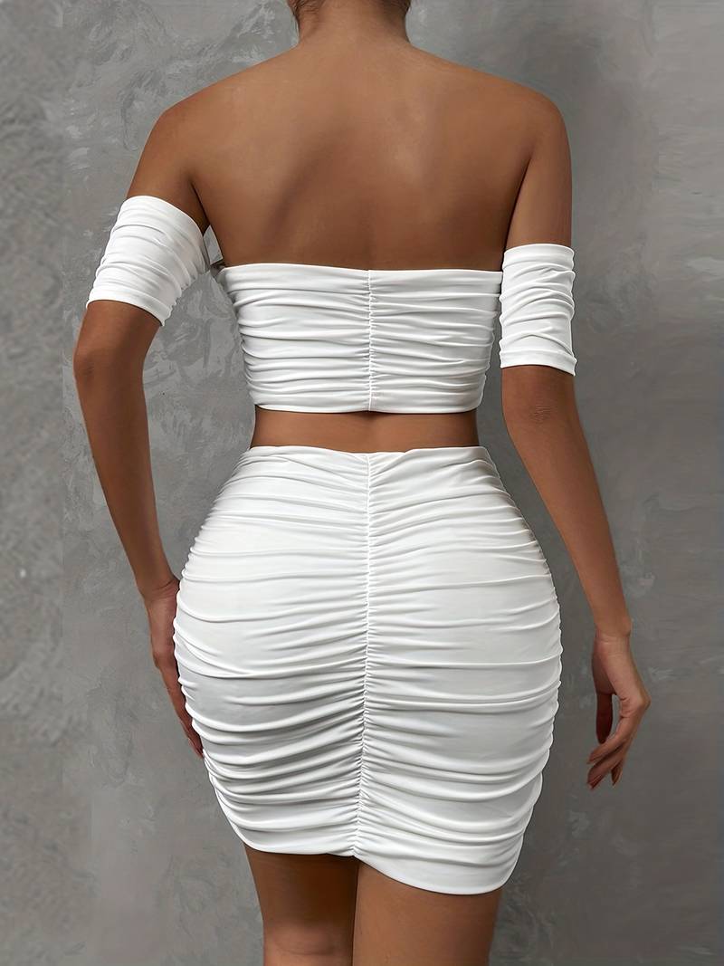 Ensemble chic avec un top à épaules dénudées et des ruchés, accompagné d'une mini-jupe assortie.