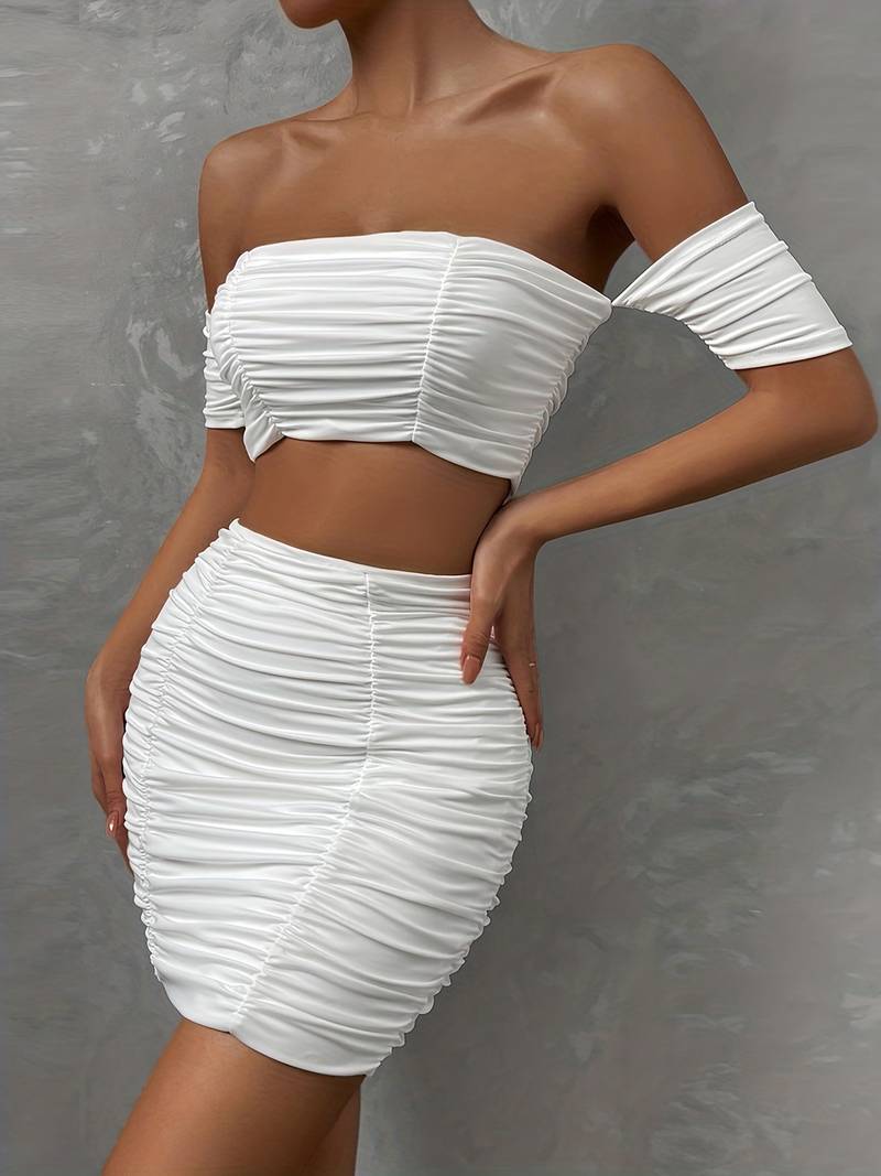 Ensemble chic avec un top à épaules dénudées et des ruchés, accompagné d'une mini-jupe assortie.