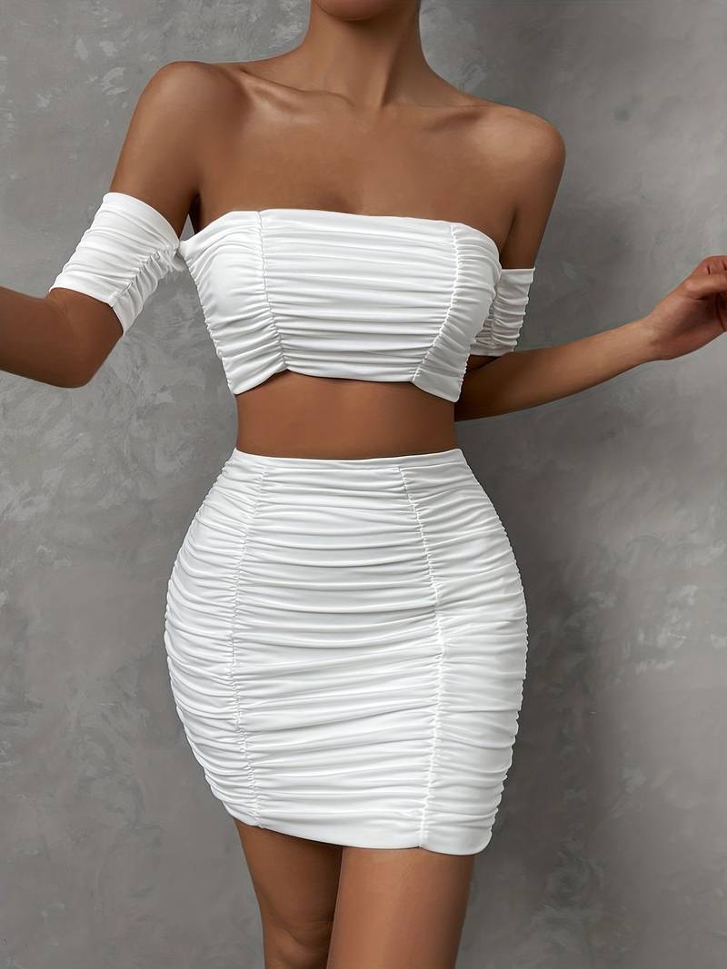 Ensemble chic avec un top à épaules dénudées et des ruchés, accompagné d'une mini-jupe assortie.
