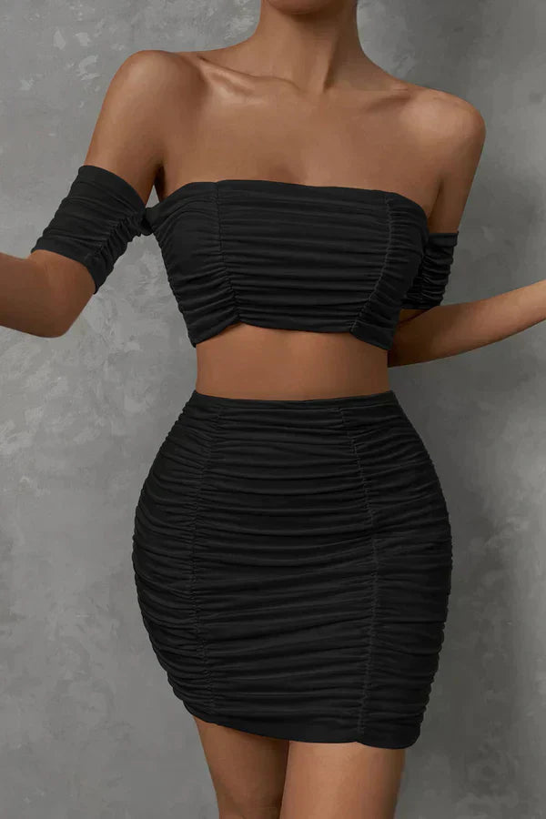 Ensemble chic avec un top à épaules dénudées et des ruchés, accompagné d'une mini-jupe assortie.