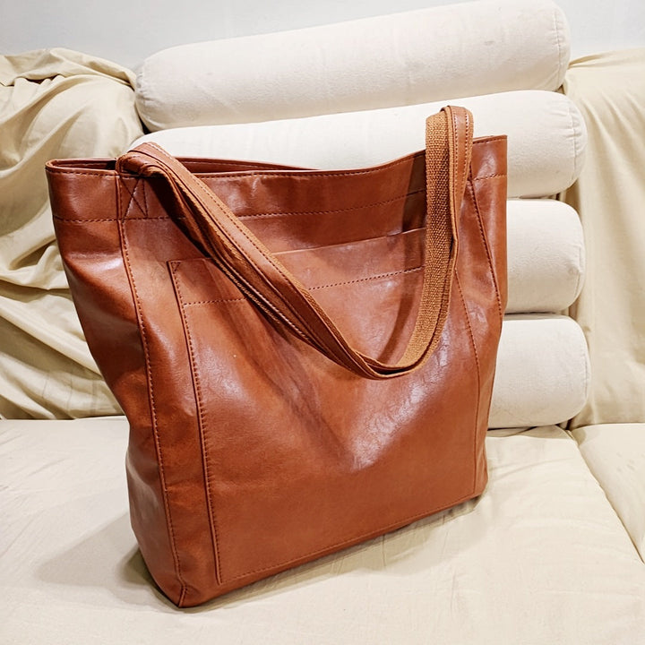 Nova - Élégante sac en cuir avec fermeture par bouton-pression et espace de rangement supplémentaire.