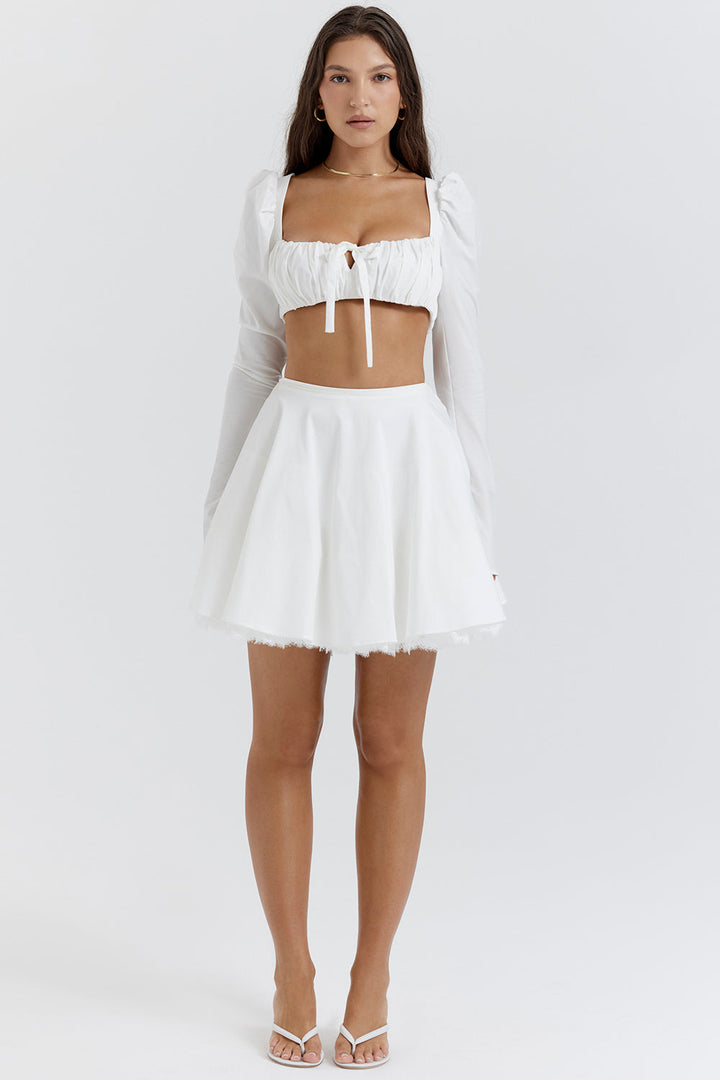 Top crop blanc élégant avec des manches bouffantes et une mini-jupe chic pour un look tendance.