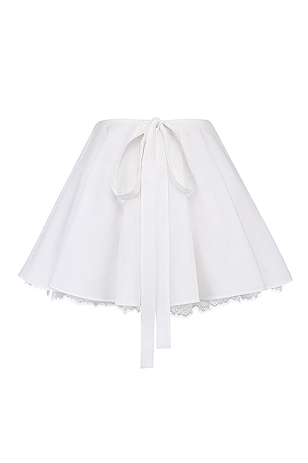 Top crop blanc élégant avec des manches bouffantes et une mini-jupe chic pour un look tendance.