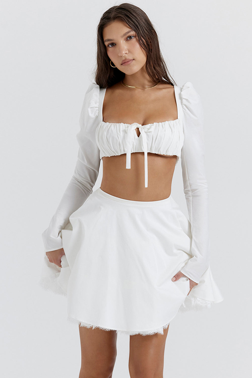 Top crop blanc élégant avec des manches bouffantes et une mini-jupe chic pour un look tendance.