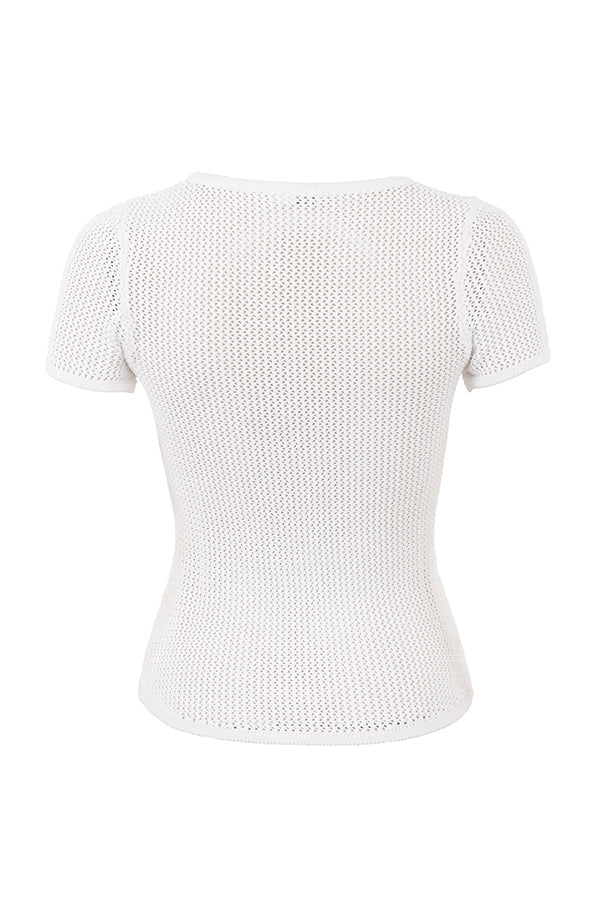 Haut cropped in tricot blanche élégante avec une mini-jupe assortie et près du corps.