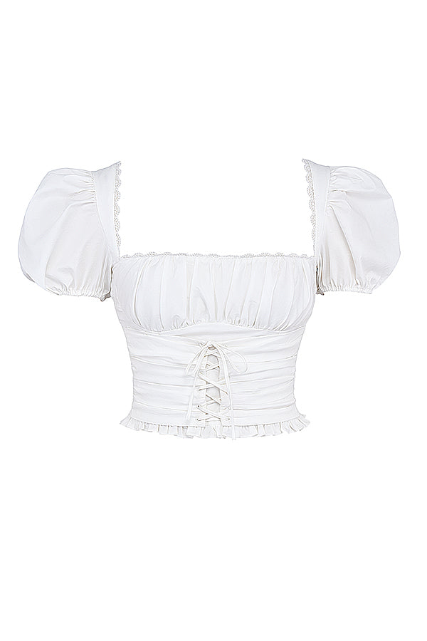 Top court plissé blanc avec mini-jupe portefeuille beige - une tenue estivale élégante pour toutes les occasions.