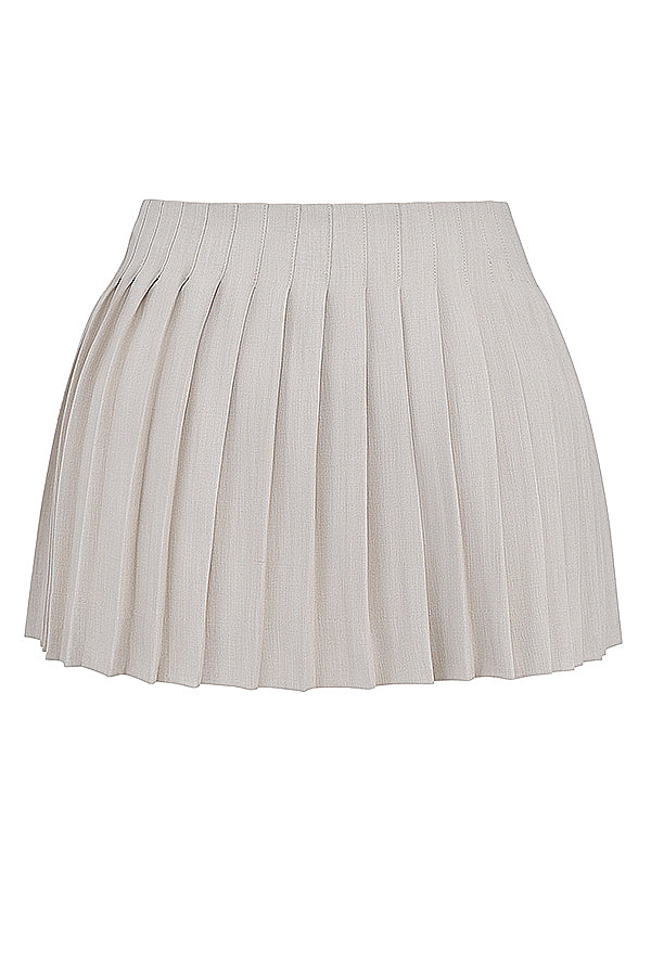 Top court plissé blanc avec mini-jupe portefeuille beige - une tenue estivale élégante pour toutes les occasions.